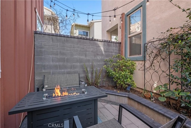 view of patio with fence and a fire pit