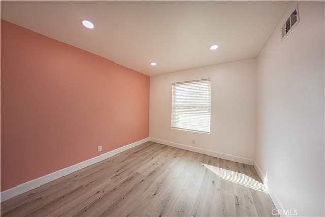 unfurnished room featuring recessed lighting, visible vents, light wood-style flooring, and baseboards