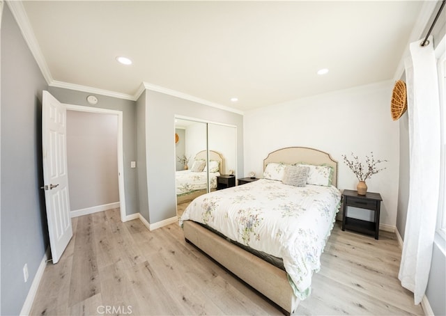 bedroom featuring light wood finished floors, baseboards, and a closet