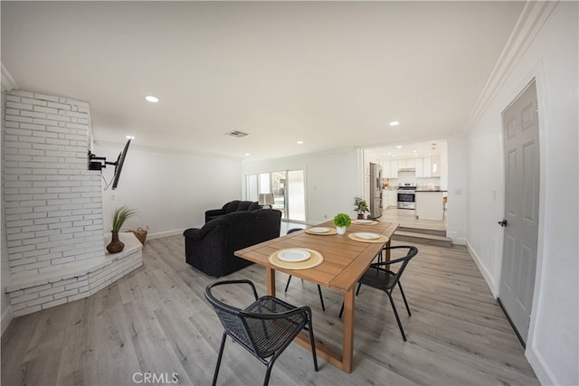 dining area featuring visible vents, baseboards, light wood-style flooring, ornamental molding, and recessed lighting