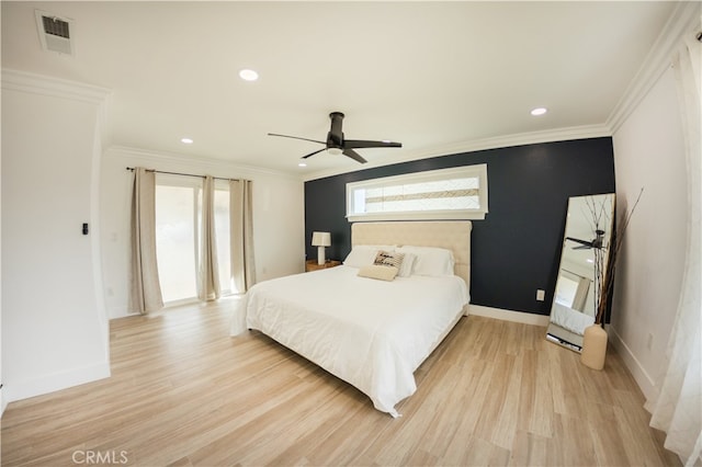 bedroom with light wood finished floors, visible vents, ornamental molding, and baseboards