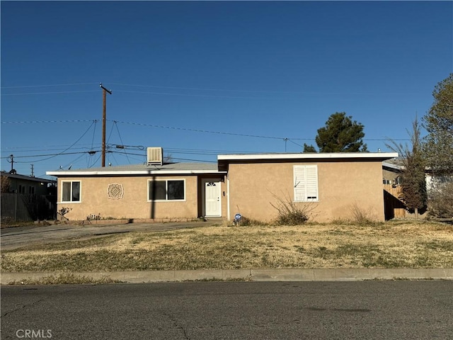 ranch-style house with central air condition unit and stucco siding