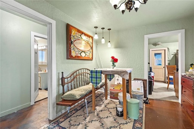 dining room with a textured wall, baseboards, and wood finished floors