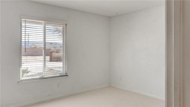 spare room featuring plenty of natural light and baseboards