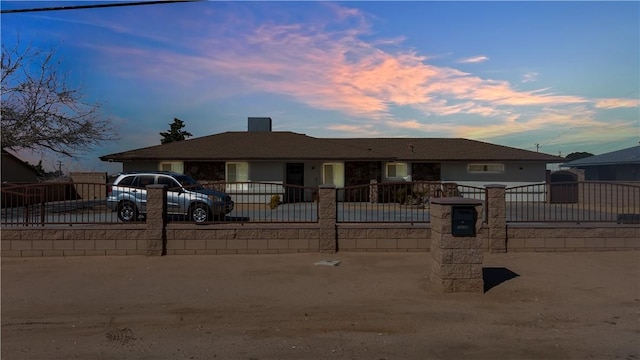 ranch-style home with a gate, driveway, and a fenced front yard