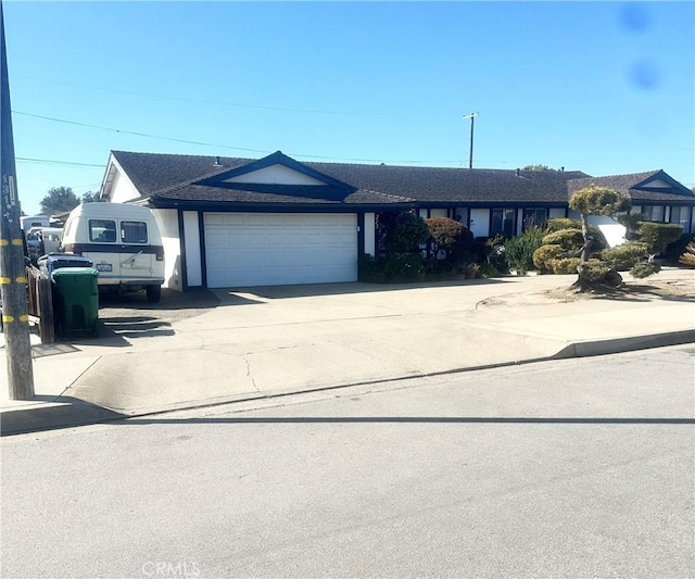 ranch-style home with a garage and concrete driveway