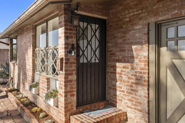 doorway to property featuring brick siding