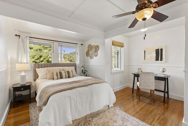 bedroom with a ceiling fan, baseboards, and wood finished floors