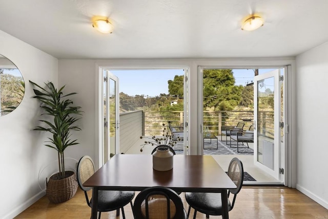 dining space with baseboards and light wood finished floors