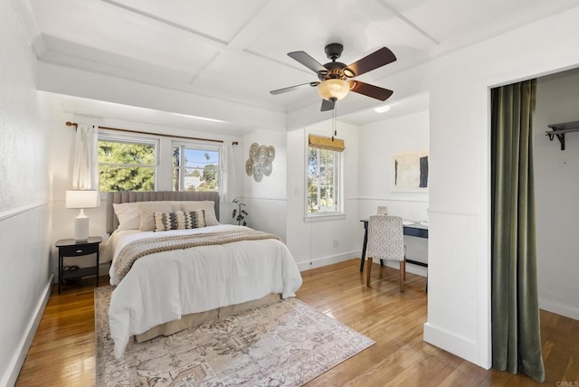 bedroom featuring coffered ceiling, ceiling fan, baseboards, and wood finished floors