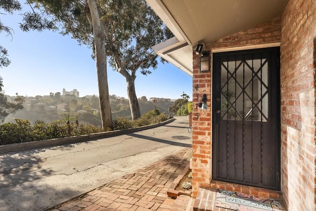 view of exterior entry featuring brick siding