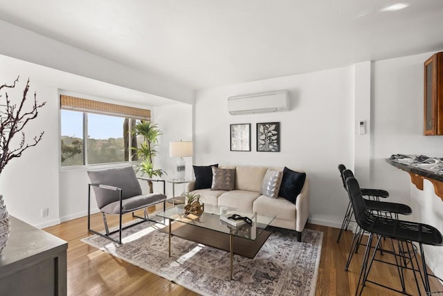 living area with a wall mounted air conditioner, baseboards, and wood finished floors