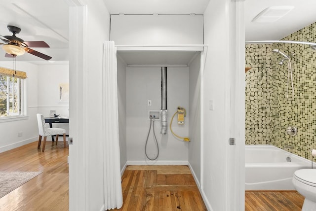 full bathroom featuring baseboards, toilet, shower / tub combination, and wood finished floors