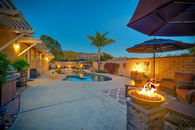 view of pool with a patio, a fenced in pool, an outdoor fire pit, a mountain view, and a fenced backyard