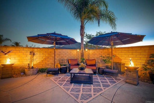 view of patio / terrace with an outdoor living space with a fire pit and fence