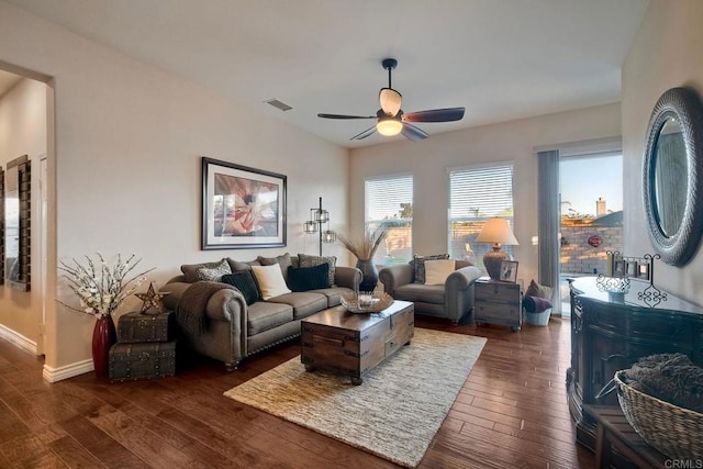 living area with visible vents, a ceiling fan, dark wood finished floors, and baseboards