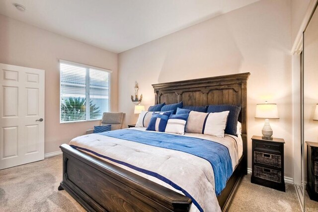 bedroom featuring light colored carpet and baseboards