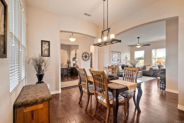 dining room with visible vents, ceiling fan, dark wood-style floors, baseboards, and arched walkways