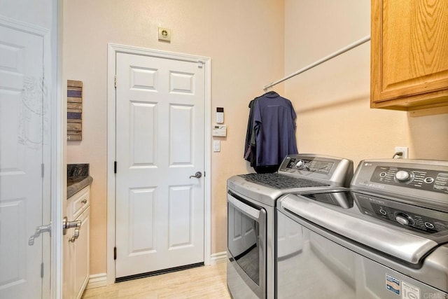 laundry room with baseboards, light wood-type flooring, cabinet space, and independent washer and dryer