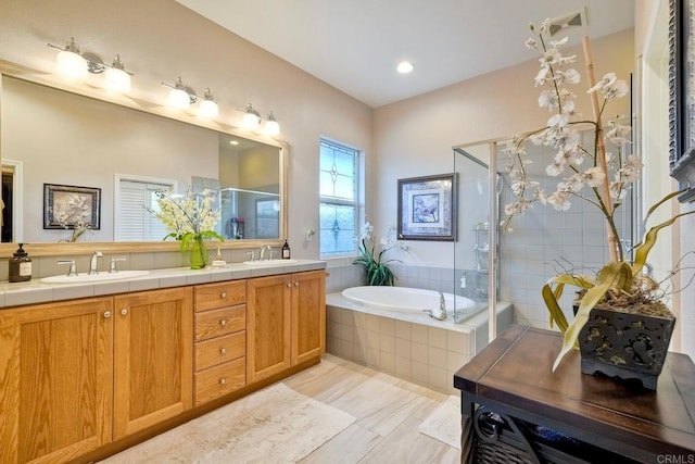 full bath featuring double vanity, a garden tub, a stall shower, and a sink