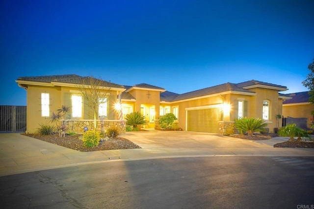 prairie-style home featuring concrete driveway, a garage, and stucco siding