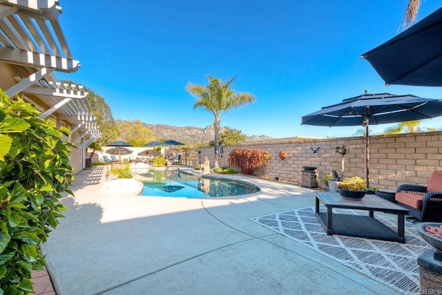 view of swimming pool featuring a fenced in pool, a patio area, a pergola, a mountain view, and a fenced backyard