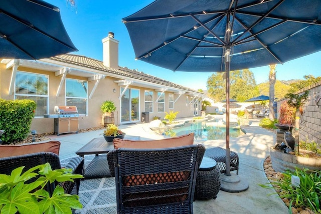 view of patio with area for grilling and a fenced in pool