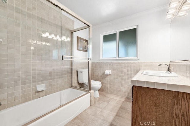 bathroom featuring crown molding, tile walls, toilet, vanity, and tile patterned flooring