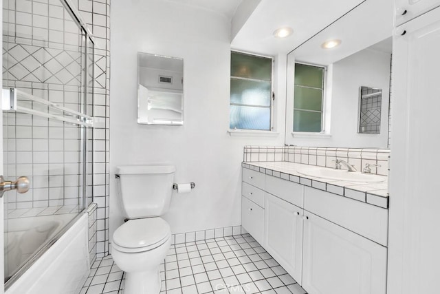 full bath with tile patterned flooring, toilet, vanity, bathing tub / shower combination, and baseboards