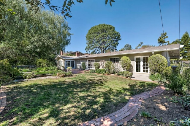 view of front of home featuring a front yard, french doors, and stucco siding