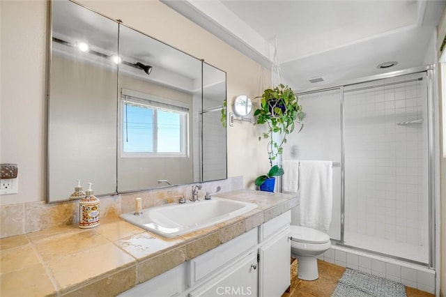 full bath featuring a stall shower, vanity, and toilet