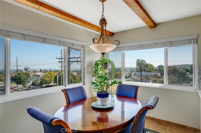 dining area featuring beamed ceiling and baseboards