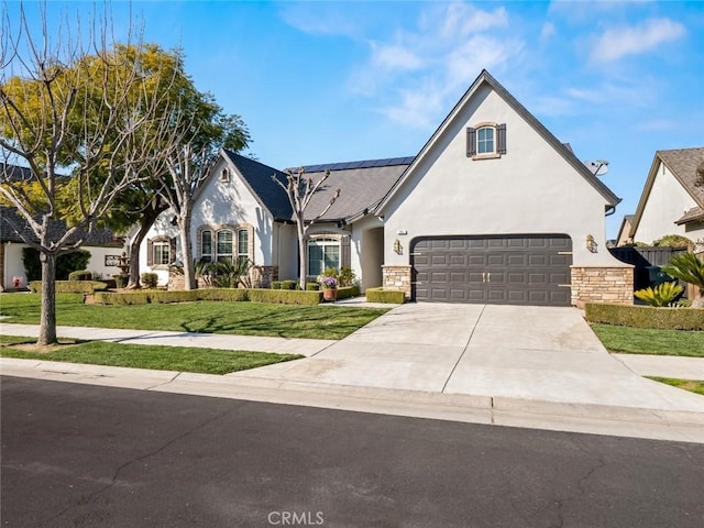 view of front of home with stone siding, a front yard, concrete driveway, and stucco siding