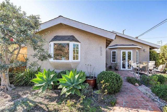 back of property with a patio, french doors, and stucco siding