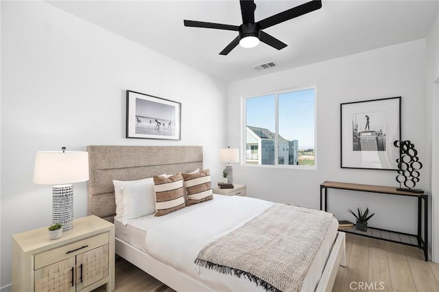 bedroom with light wood-type flooring, visible vents, and a ceiling fan