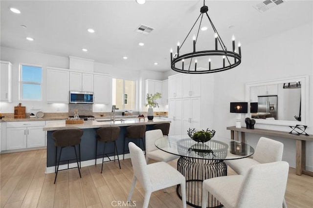 dining room with recessed lighting, visible vents, and light wood-style flooring