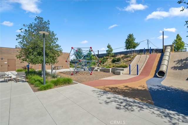 view of jungle gym with a patio and fence