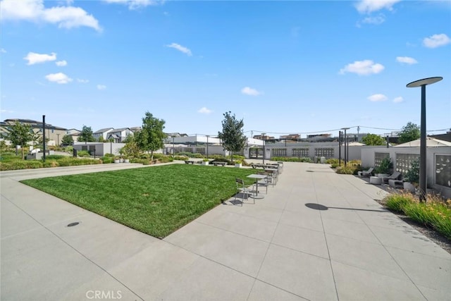 view of home's community with a patio area, fence, and a yard