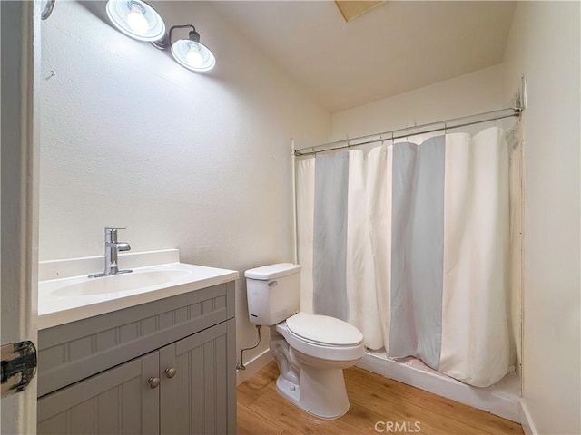 full bath with a shower with shower curtain, vanity, toilet, and wood finished floors