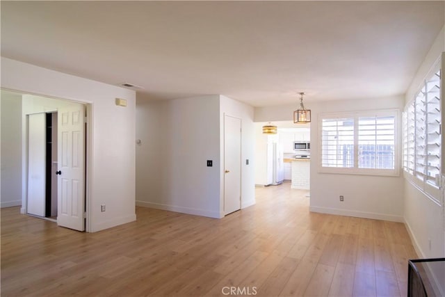 empty room with light wood-style flooring and baseboards