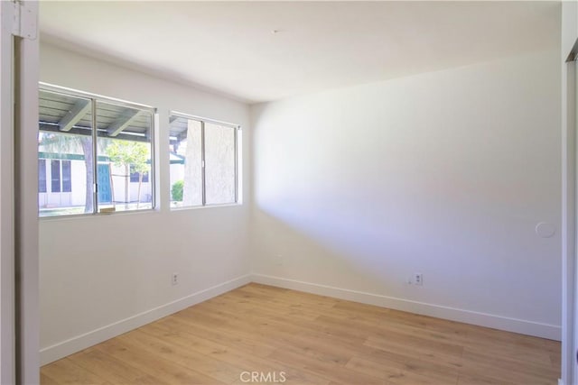 unfurnished room with light wood-style floors and baseboards