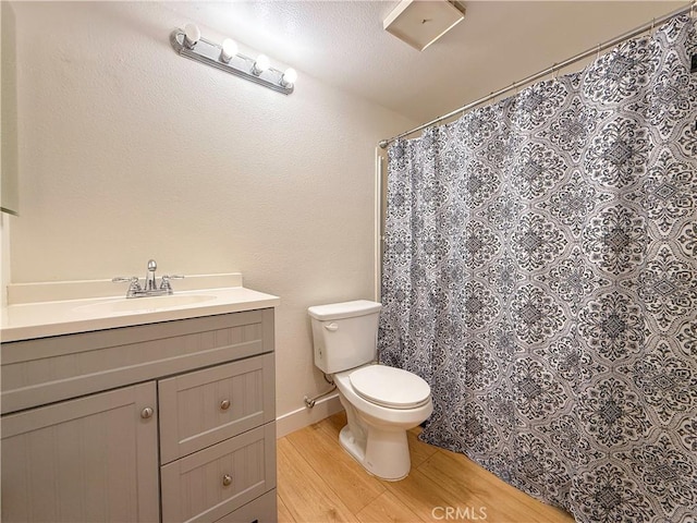 full bathroom featuring toilet, vanity, wood finished floors, a shower with curtain, and baseboards