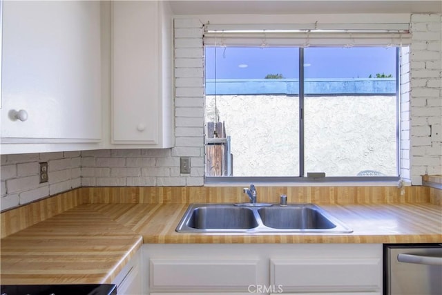 kitchen featuring white cabinetry, a sink, and stainless steel dishwasher