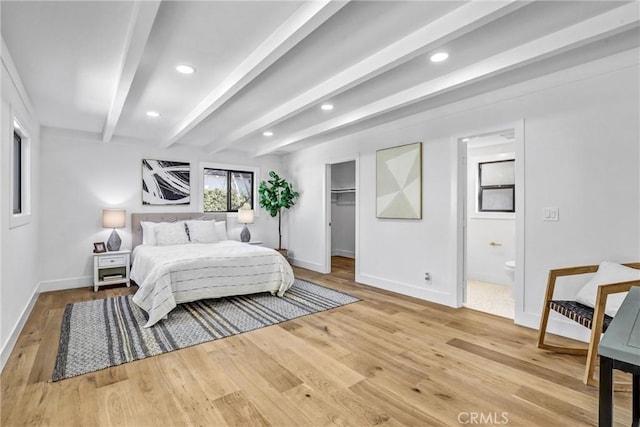 bedroom featuring a walk in closet, beam ceiling, recessed lighting, wood finished floors, and baseboards