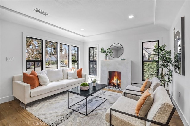 living area with a wealth of natural light, wood finished floors, and visible vents