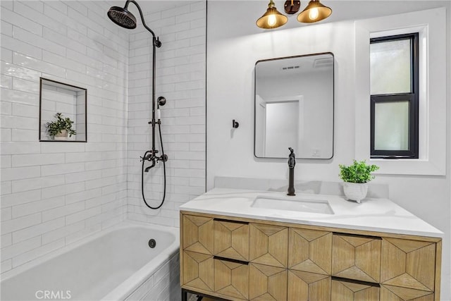 bathroom featuring tiled shower / bath and vanity