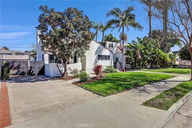 view of front of property with fence, a front lawn, and stucco siding