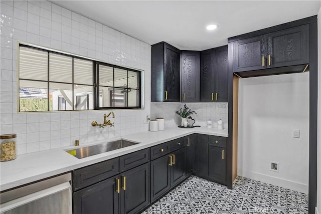 kitchen with a sink, baseboards, light countertops, stainless steel dishwasher, and backsplash