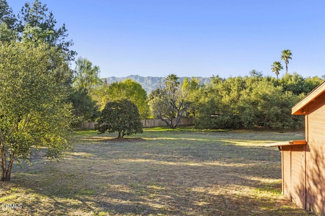 view of yard featuring fence and a mountain view