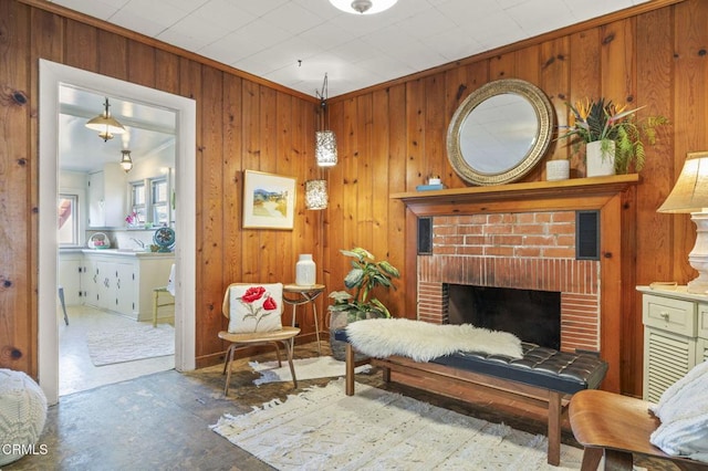 living area featuring wooden walls, visible vents, a fireplace, and ornamental molding